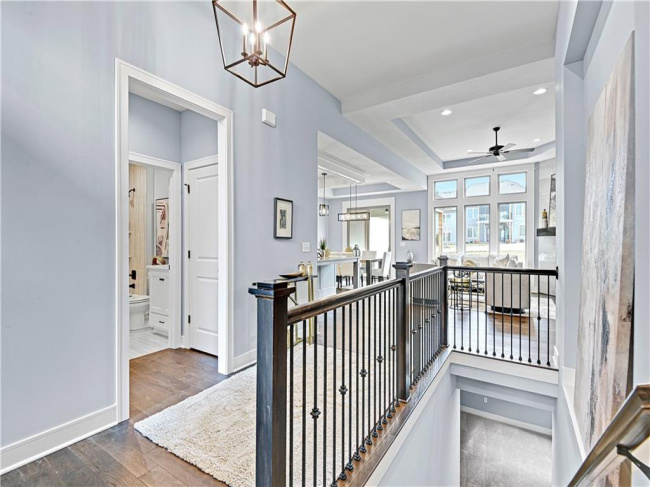 Corridor with hardwood / wood-style floors and an inviting chandelier